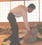 腰痛アカデミーで腰痛やヘルニア、狭窄症、坐骨神経痛を克服する坂戸孝志先生による個別サポートの様子